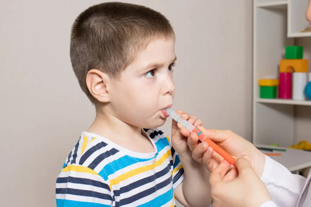 The pediatrician or nurse gives the child syrup in a measuring syringe.