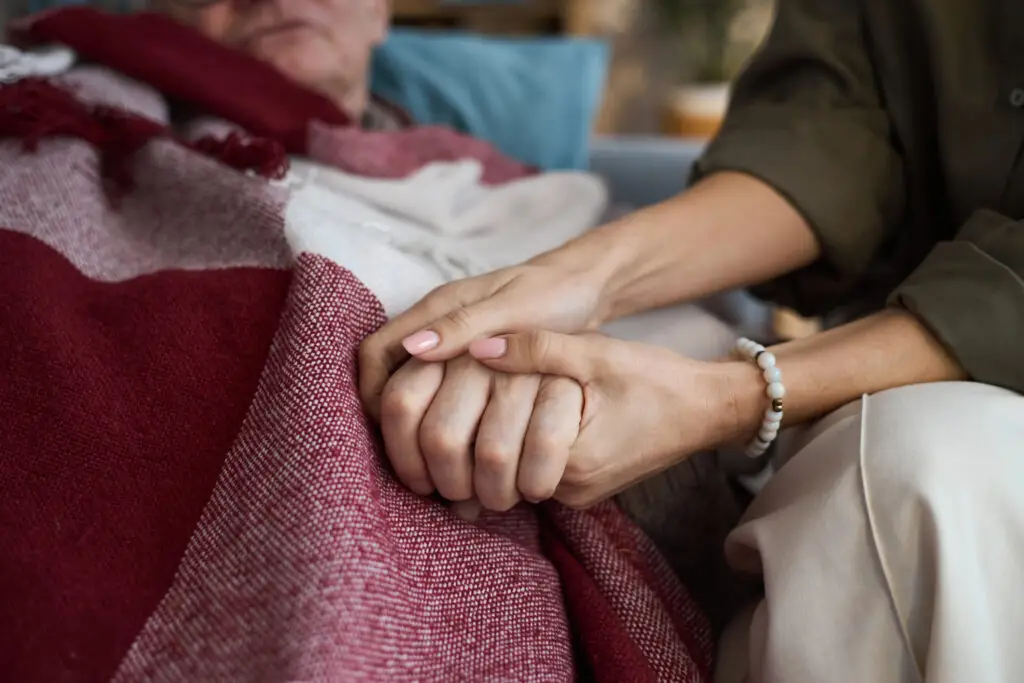 Middle Aged Woman Comforting Senior Man in Bed